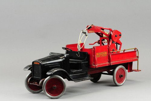 BUDDY 'L' WRECKING TRUCK: C. 1926, black open seat cab with red service body, winch with hook on swivel base, railed body to rear platform, aluminum wheels have painted centers, a nice example. 27" l.