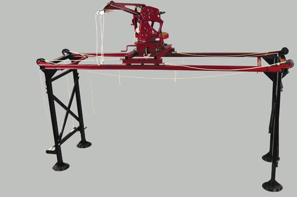 BUDDY 'L' TRAVELING CRANE: C. 1928, pressed steel, black foldable frame with red crane guides and crane boom, needs to be readjusted or refitted, older restoration to original toy. 46" x 33 1/4".