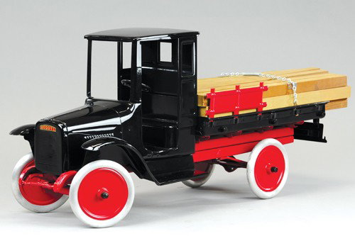 BUDDY 'L' LUMBER TRUCK: C. 1926, older restoration to an original toy, correct replacement load of lumber, enclosed doorless black cab, open body has red side stakes, aluminum wheels with painted centers, lift down gate. 24"