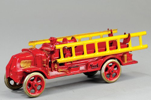 EARLY ARCADE MACK LADDER TRUCK: Cast iron, painted in red overall, open seat cab and service body, cast hose reel, nickel spoke wheels have painted centers, cast driver, tin ladders on sides. 9 1/2" l.
