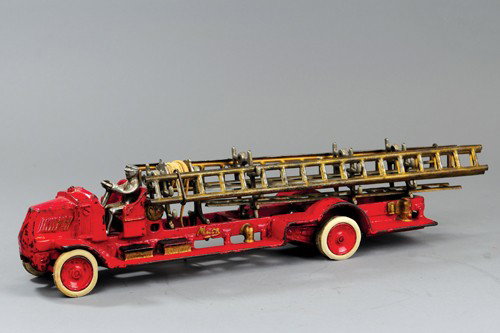 ARCADE MACK LADDER TRUCK: Cast iron, painted in red overall, open seat cab and service body, features nickel ladder supports and hose reel, side ladders are made of tin, includes six ladders, nickel driver, disc wheels, rubber