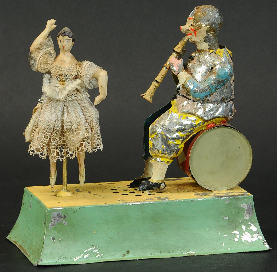 GUNTHERMANN MUSICIAN & BALLERINA: 63. GUNTHERMANN MUSICIAN & BALLERINA | Nice motion with plink plank music emitting from base wind-up. | 8" l. | Clown is flaked primarily to one side, all original (VG - Exc. Cond.) | $800 - $1,200