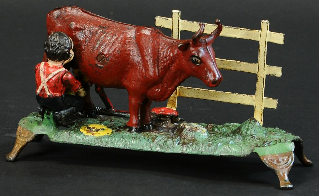 MILKING COW MECHANICAL BANK: 549. MILKING COW MECHANICAL BANK | J&E Stevens Co. | 10" l. | Fence, leg and tail replaced, one pedestal leg repaired, touch-up to man and one cow leg, (VG Cond.) | $1,500 - $2,500