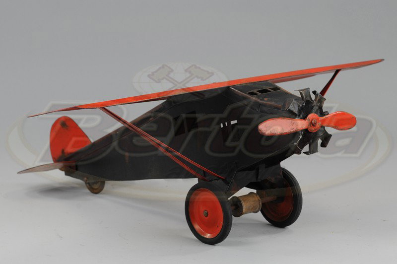 STEELCRAFT EARLY AIRPLANE: C. 1929, pressed steel, painted in black fuselage with red wing, single red prop, disc wheels, rubber tires. 23 1/2" l.