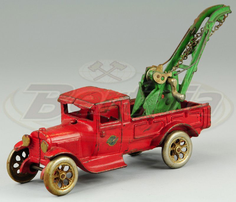 ARCADE FORD WRECKER: Cast iron, painted in red body, open bed contains green weaver crane with chain, missing driver. 11" to boom.