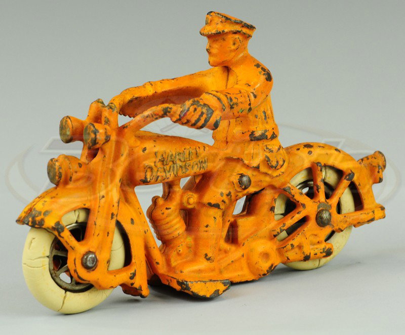 HARLEY DAVIDSON CYCLE WITH RIDER: Champion, cast iron, painted in orange overall, embossed gas tank, rubber tires, nickel spoke wheels. 5 1/4" l.