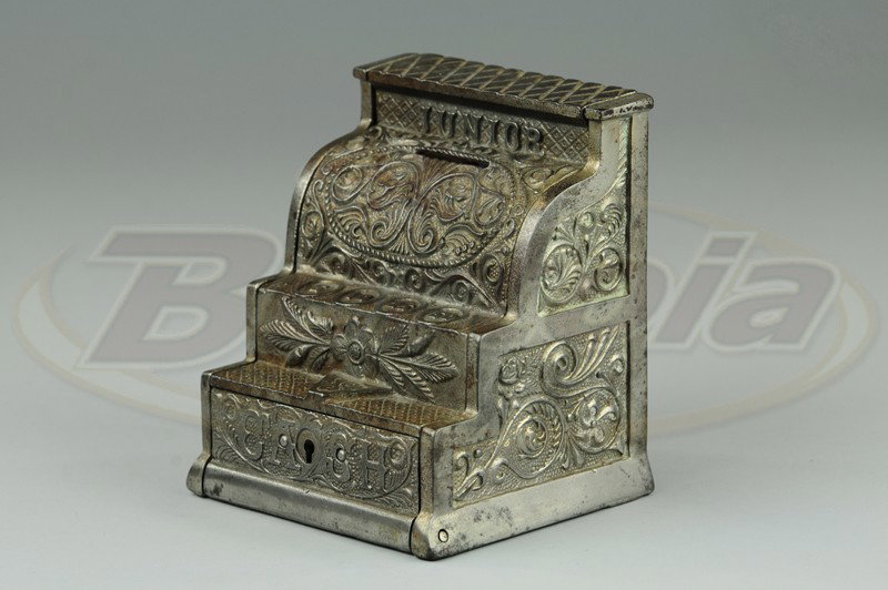 JUNIOR CASH REGISTER STILL BANK: J&E Stevens, nickel cast iron, very ornate molding, lettered Junior Cash on front, key lock drawer. 5 1/4" h x 4 5/8" w.