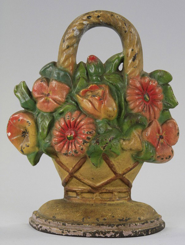 FLOWERS IN WOVEN BASKET DOORSTOP: Signed "LACS," cast iron, colorful arrangement with embossed basket, with handle on top. 10" x 8".