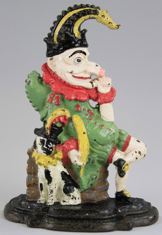 PUNCH DOORSTOP: Extensive casting details, depicts the famed English character in whimsical pose, very colorful, dog cast at side of chair. 12" h x 7 1/4" w.