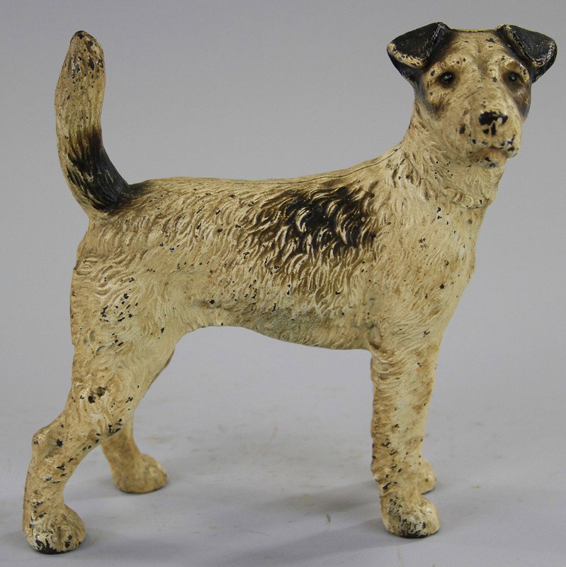 FOX TERRIER DOORSTOP: Hubley, right facing full figure example, done in beige with black and brown markings. 8" h.