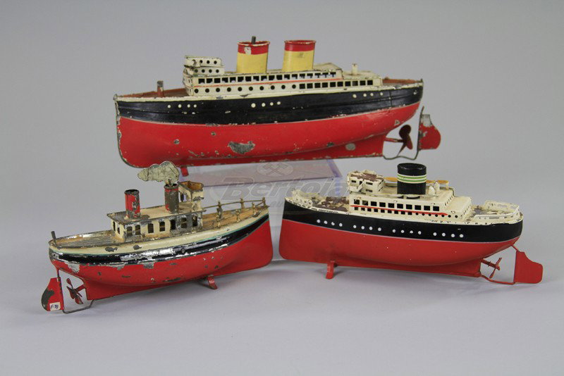 THREE SMALL OCEANLINERS: Tin liners done in red and black hulls, white upper deck cabins, two have two stacks, one has one stack, includes one with Carette smoke stack key. 7 1/4" to 10 1/4".