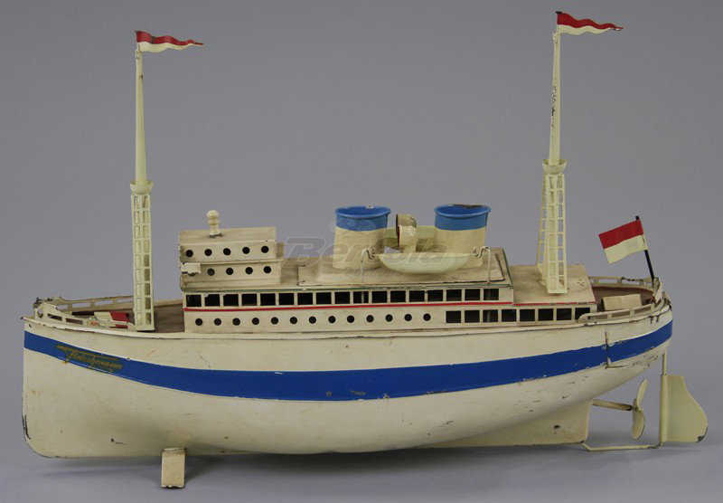 FLEISCHMANN OCEANLINER: Germany, hand painted, done in white overall, side blue band, decal on side, upper deck cabin, two masts, two funnels and life boats, clockwork driven. 12 3/4" l.