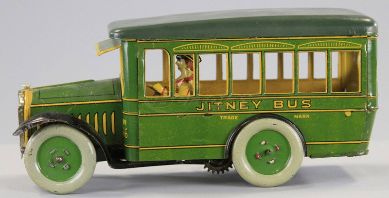 STRAUSS JITNEY BUS: Lithographed tin, green body, yellow trim, seated driver, disc wheels, key wind operated, plated grille. 9 1/2" l.