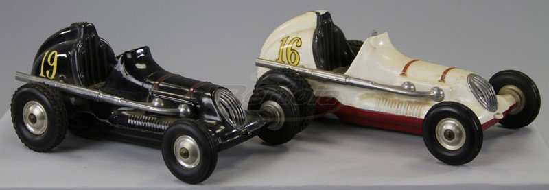 LOT OF TWO THIMBLE DRUM RACERS: Both made of die cast with rubber tires, pusher types, one black, one in white and red, tether rings on sides. 9"long.