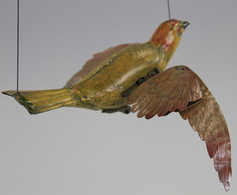 LEHMANN MECHANICAL FLYING BIRD: Germany, hand painted tin body done in yellow and red highlights with paste board lithographed wings. 10" wing.