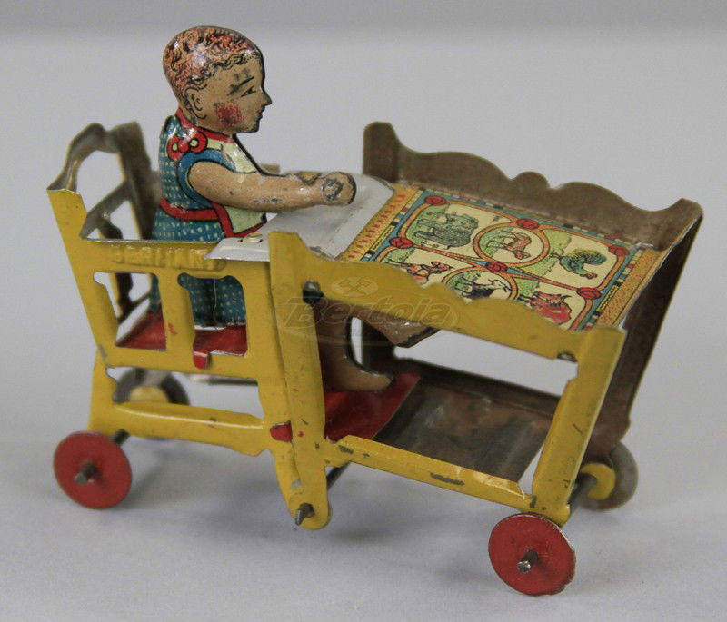 CHILD IN HIGH CHAIR PENNY TOY: Fischer, Germany, lithographed tin, depicts child seated in foldable high chair and table on wheels. 4" h.