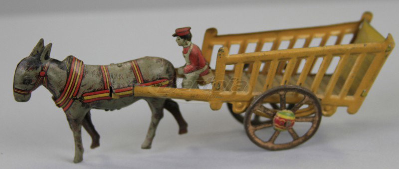 MEIER DONKEY CART PENNY TOY: Germany, lithographed tin, open stake wagon, yellow sides, horse drawn, seated driver. 6" l.