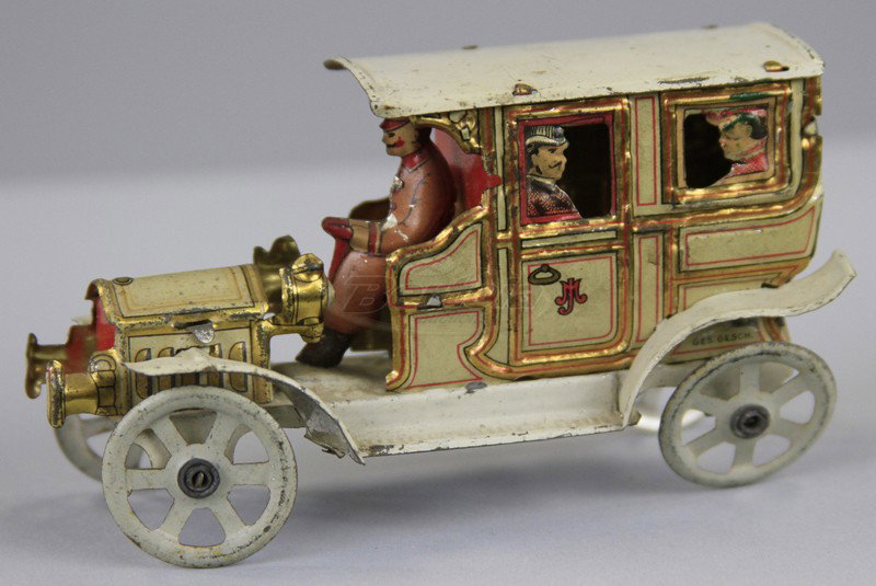 DISTLER LIMOUSINE PENNY TOY: Germany, lithographed tin, luxury limo with passenger die cuts at windows, full appointments, spoke wheels, seated chauffer. 4 1/8" l.