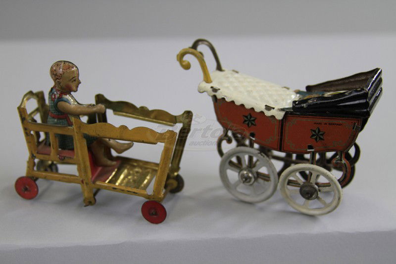BABY PRAM AND BABY IN HIGH CHAIR PENNY TOYS: Germany, both lithographed in tin, includes pram with baby die cut and child in folding high chair on wheels, pram by Fischer, missing food tray. 2 3/4" to 3 1/2".