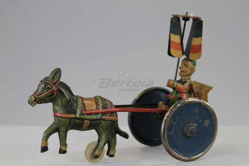 CLOWN RIDING DONKEY CART: Gama, Germany, lithographed tin, depicts seated clown with overhead whirlygig, drawn by donkey, large disc wheels, key wind driven. 7 3/4" l.