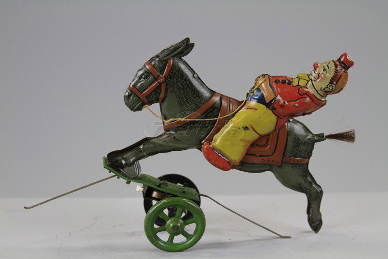 EINFALT CLOWN RIDING DONKEY: Germany, lithographed tin, depicts clown in colorful outfit on donkey, wheeled platform and wire band allow a stubborn donkey effect, key wind driven. 6" l.