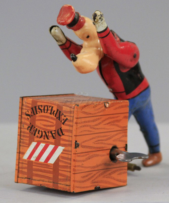 GOOFY ROLLING EXPLOSIVE CRATE: France, lithographed tin, depicts Goofy seemingly able to roll explosives crate when key wind is activated, head is made of plastic. 4 1/2" h.