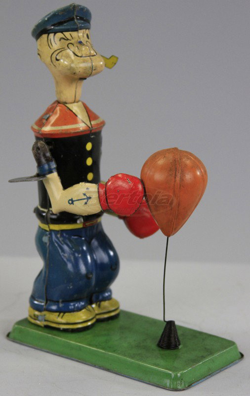 CHEIN POPEYE FLOOR PUNCHER: Lithographed tin, depicts Popeye punching self standing celluloid punching bag, clockwork driven. 7" h.
