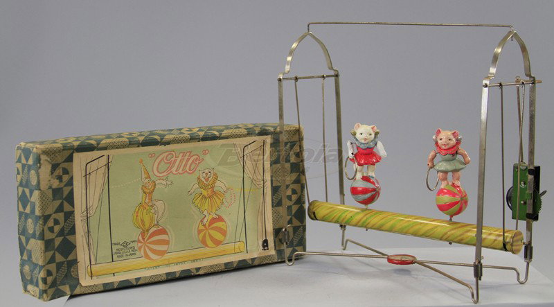 "OTTO" BOXED KITTY PLAYLAND TOY: Pre-war Japanese celluloid and tin toy, features two cats standing on beach balls, litho tin bar suspends on nickel frame, able to swing when key wind is operated, nice paper litho lid label. 9 1/2" w