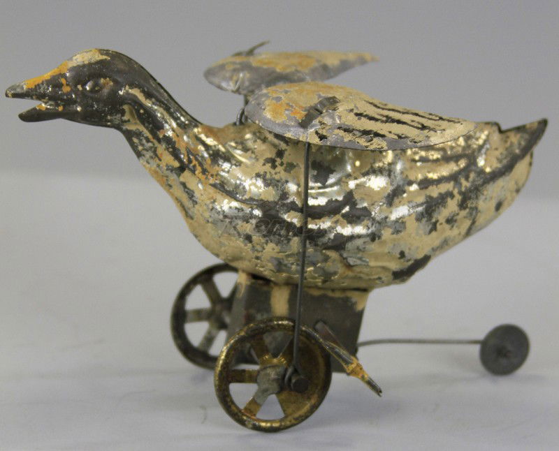 GUNTHERMANN WALKING DUCK: Germany, hand painted tin, white body, depicted on wheeled platform, clockwork driven, moves and flaps wings. 5 1/2" l.