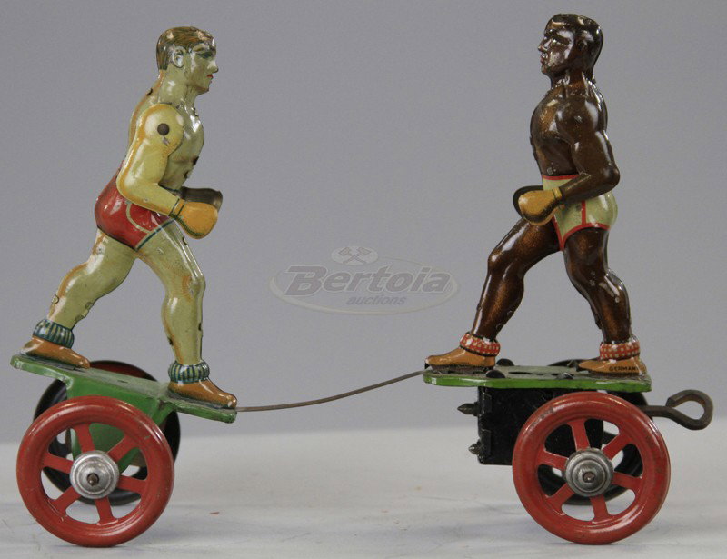 EINFALT BOXERS TOY: Germany, lithographed tin, depicts two boxers on platforms, key wind operated, scarce black and white boxer version, has been suggested that it was Joe Louis and Max Schmelling. 6 1/2" l.