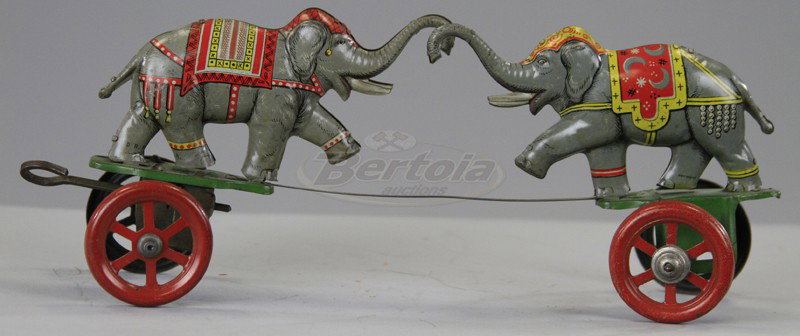 EINFALT ELEPHANTS ON PLATFORM TOY: Germany, very rare toy, lithographed tin, depicts two parade elephants apparently performing a charge when key wind is operated. 9 1/2" l.