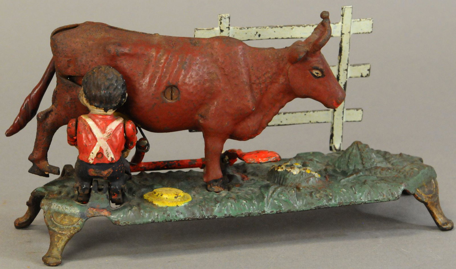 MILKING COW MECHANICAL BANK: 564. MILKING COW MECHANICAL BANK | 9.5" l. | Fence, tail, and lever repainted or replaced, crack to base has been repaired. | $1,000 - $2,000