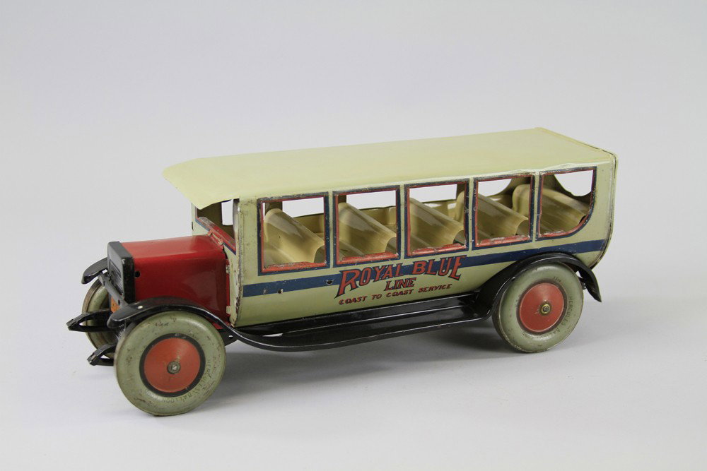 ROYAL BLUE LINE BUS: Chein, large scale lithographed tin toy bus, done in tan overall and highlighted with red hood and trim, large disc wheels, interior bench seating. 18" l.