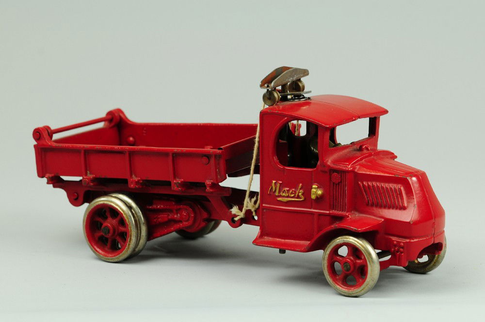 ARCADE MACK T-BAR DUMP TRUCK: Cast iron, done in red with t-bar pulley system, gate and nickel wheels, dual at rear. 12" l.