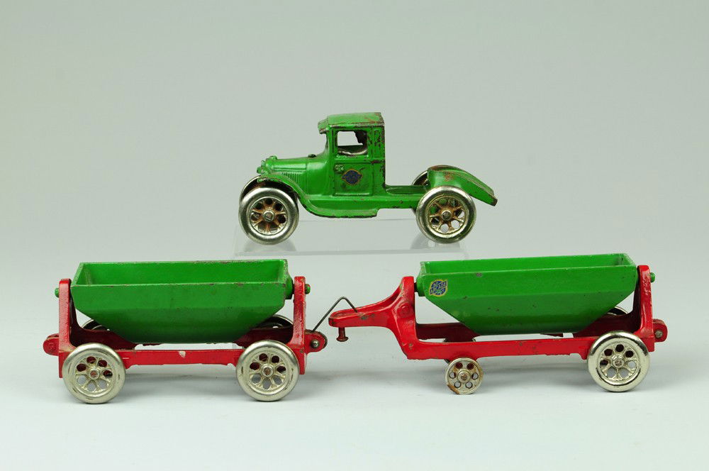 ARCADE TRUCK WITH SIDE DUMP TRAILER: Scarce toy, cast iron, enclosed Model 'A' Ford tractor with side dumping open cars in green on red frames, nickel wheels. 20" l.