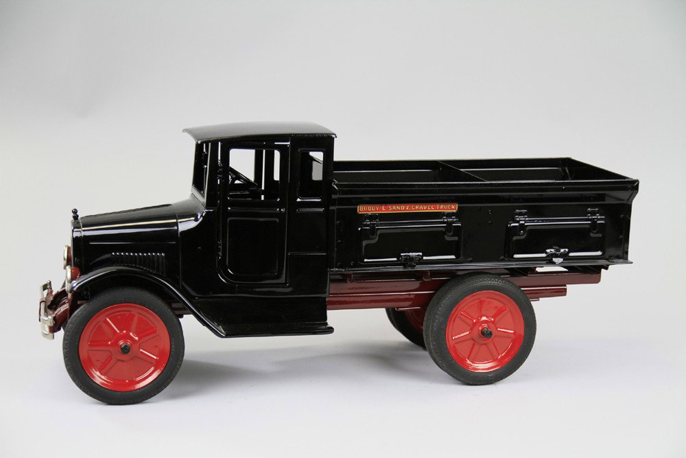 BUDDY 'L' SAND AND GRAVEL TRUCK WITH DOORS: C. 1926, pressed steel, painted black overall, classic opening door cab style with four opening doors on body, includes load divider, disc wheels, red painted centers. 25" l.
