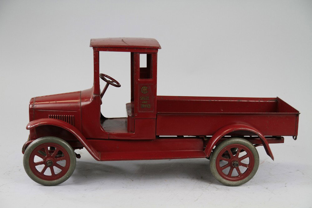 BUDDY 'L' IHC RED BABY EXPRESS TRUCK: C. 1920's, pressed steel, all red, enclosed cab with open cargo section and drop tailgate, spoke wheels, operating steering wheel, distributed to McCormick-Deering dealers only, Red Babies appeared in