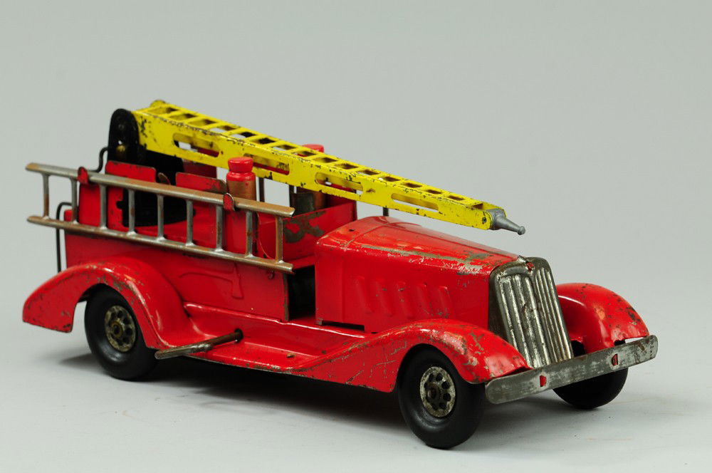 GIRARD FIRE TRUCK: Pressed steel, features yellow water tower and side mounted tin ladder, wind up action, painted in red overall, rubber tires. 14" l.