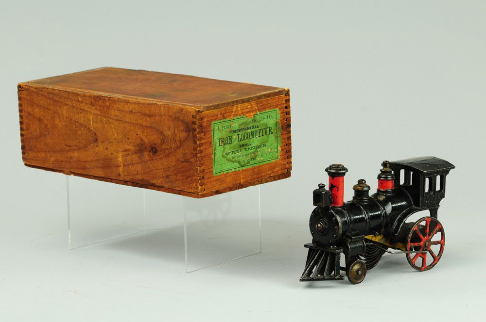 IVES BOXED CLOCKWORK LOCOMOTIVE: Pat. 1884, cast iron, painted in black, red trim on stack and spoke wheels. 7" l.
