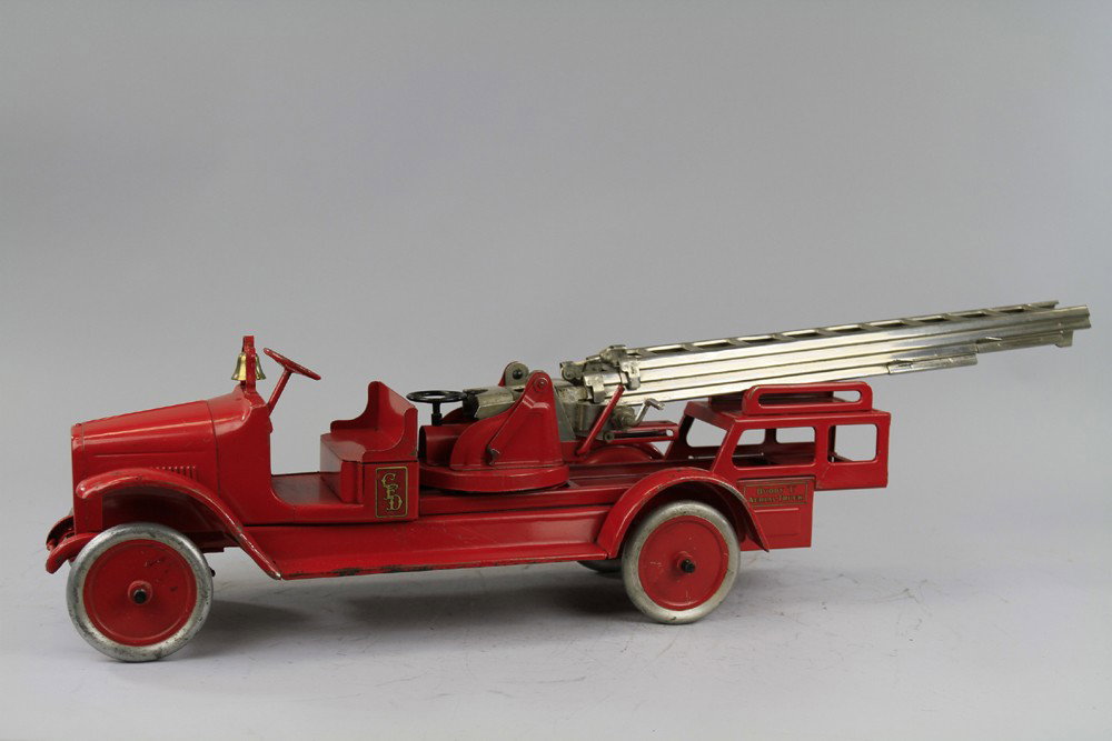 BUDDY 'L' AERIAL LADDER TRUCK: Pressed steel, done in red overall, nickel ladder, full length running boards, brass bell, ladder extends 4 1/2 feet, small hand wheel will rotate ladder, hydraulic aerial lift. 36" l.