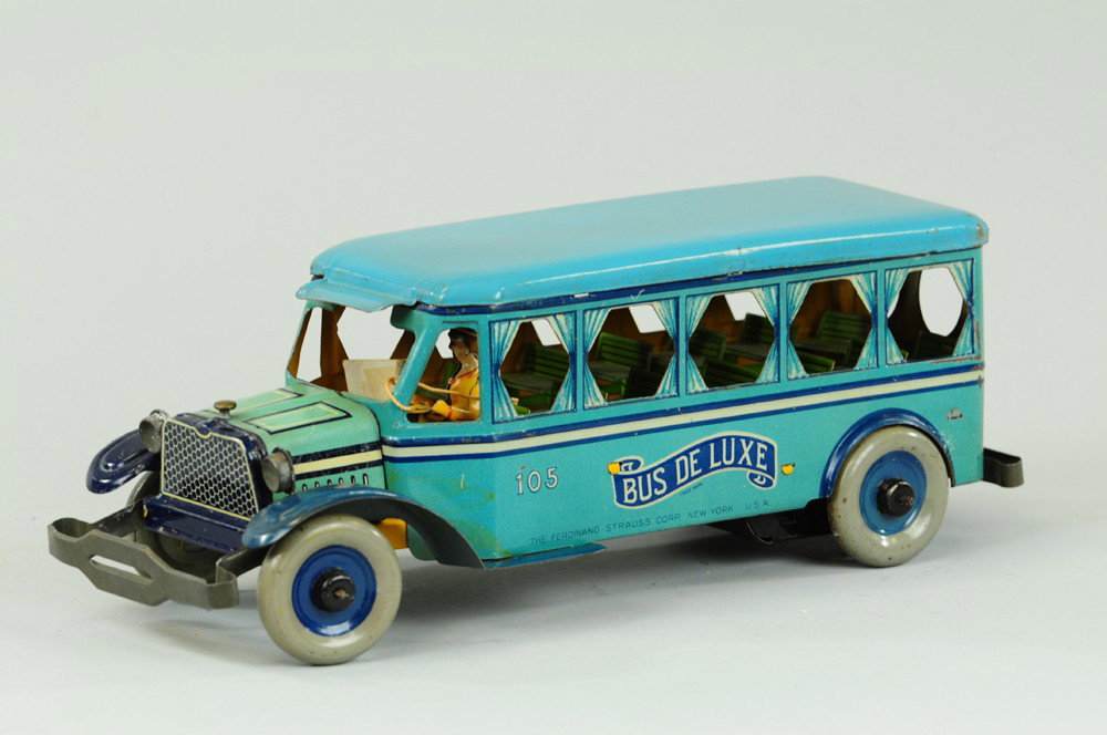STRAUSS "BUS De LUXE": Lithographed tin, done in blue body, dark blue fenders, die cast curtains, full interior seating, clockwork driven, a nice example with seated driver. 13 1/2" l.