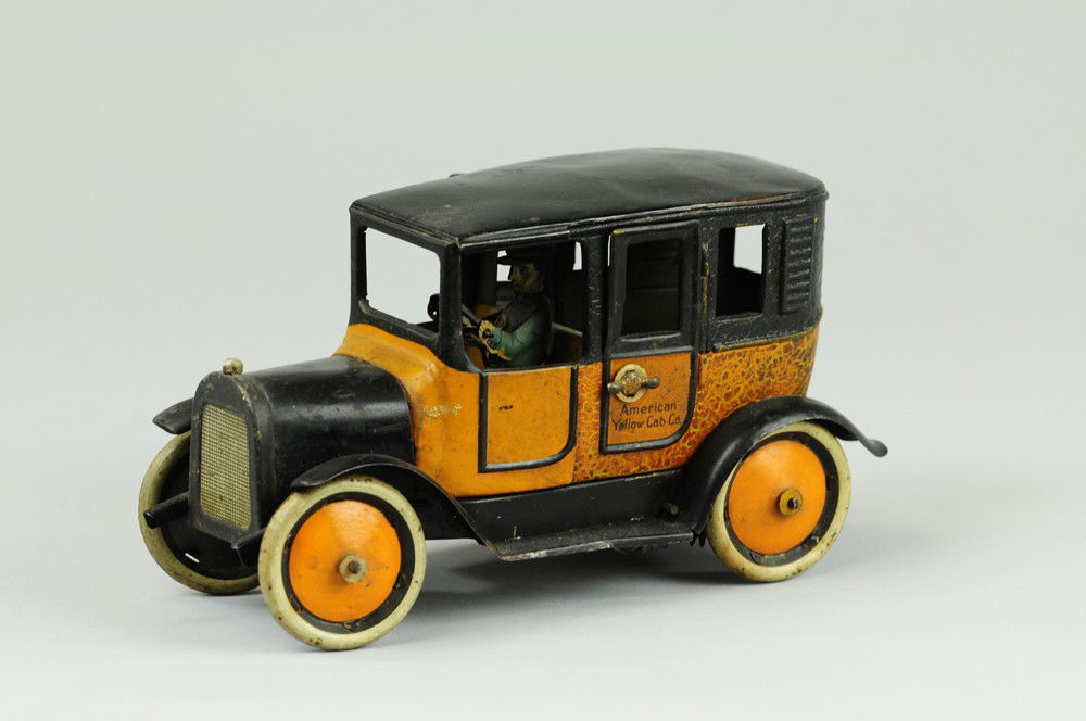 BING YELLOW TAXI: Germany, classic orange and black body, reads "Yellow Taxi" on opening door, disc wheels, seated driver, clockwork driven, spare on rear. 8 1/2" l.