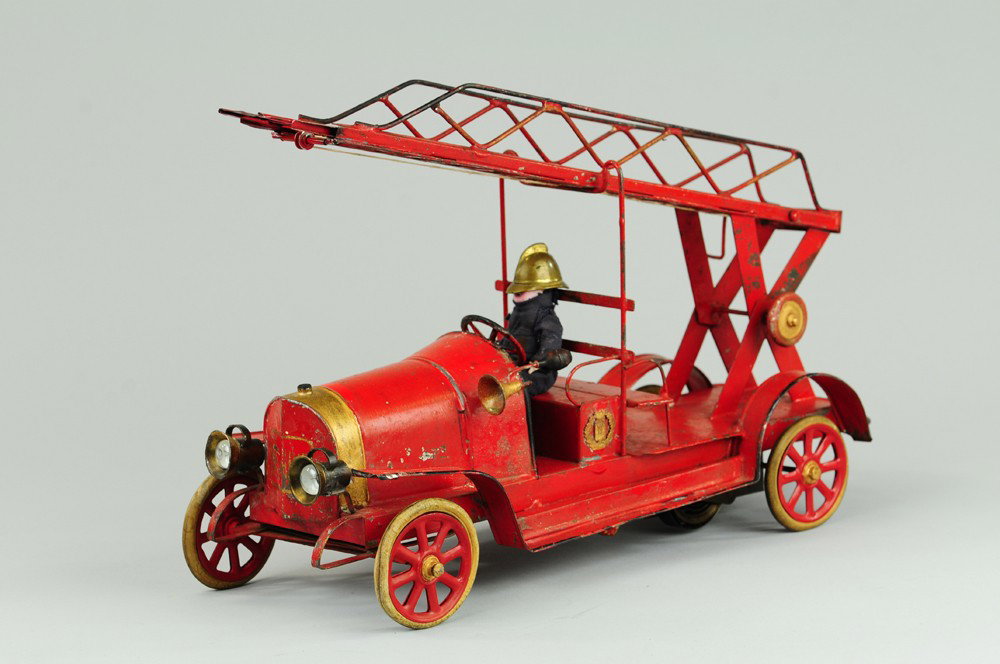 TIPPCO FIRE LADDER TRUCK: Germany, c. 1930's done in tin lithography, red open frame contains four seated firemen, long extension ladder is rear mounted in swivel base, clockwork action. 12" l.
