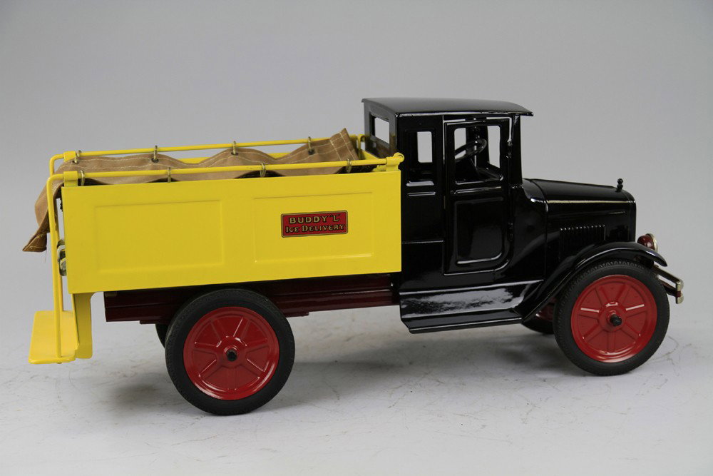 BUDDY 'L' ICE TRUCK: Pressed steel, enclosed cab painted in black with open service body done in yellow. Contains railed sides, rear platform and canopy top, dual rubber wheels. 25 1/2" l.