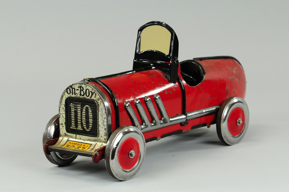 "OH-BOY" KIDDIE TOY RACER: Lithographed tin, large scale toy racer done in red, exhaust pipes on sides, colorful decals on side, grille reads, "Oh-Boy 110," license decal. 19" l.