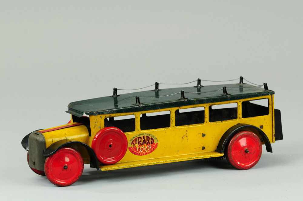 GIRARD TOY BUS LINE: Lithographed tin, done in red, yellow and green with yellow truck, disc wheels, clockwork driven, side decal reads, "Girard Toys - Making Childhood's Hour Happier". 14" l.