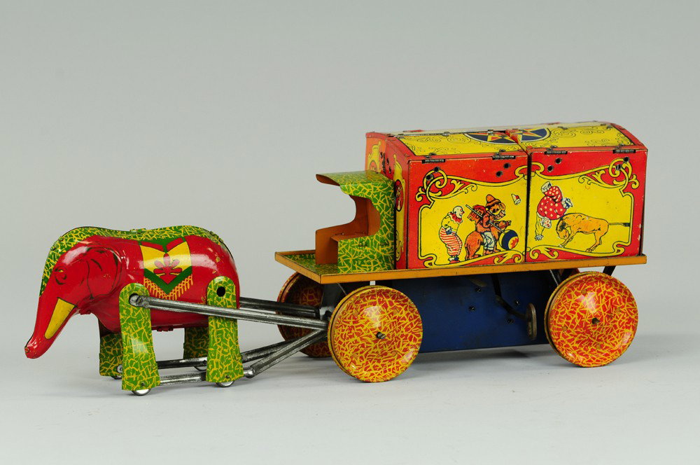 CIRCUS WAGON MENAGERIE TRUCK: Lithographed tin, clockwork driven, wagon drawn by articulated elephant, folding cages with four wheeled figures, including camel, giraffe, lion, tiger and clown, very colorful graphics, unique animal