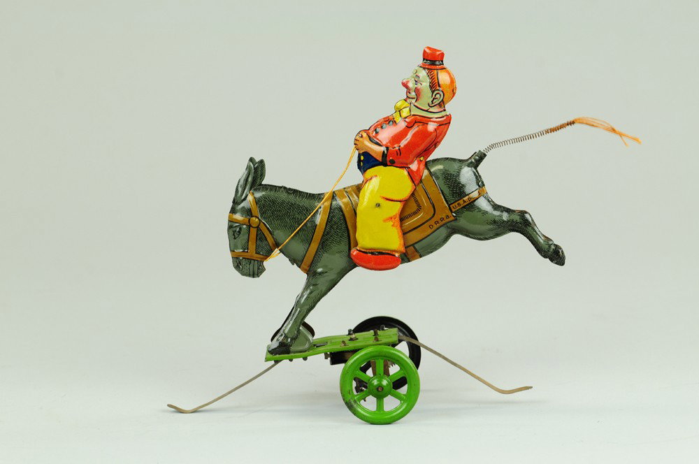 EINFALT CLOWN ON DONKEY TOY: Germany, lithographed tin, amusing depiction of clown riding bucking donkey on elaborate wheeled support with clockwork mechanism. 6" l.