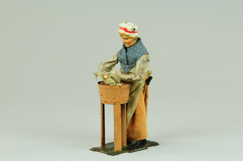 MARTIN WIND-UP WASHING WOMAN: France, amusing hand painted early toy depicts woman washing clothes by hand, tub appears on tall supports. 8" h.
