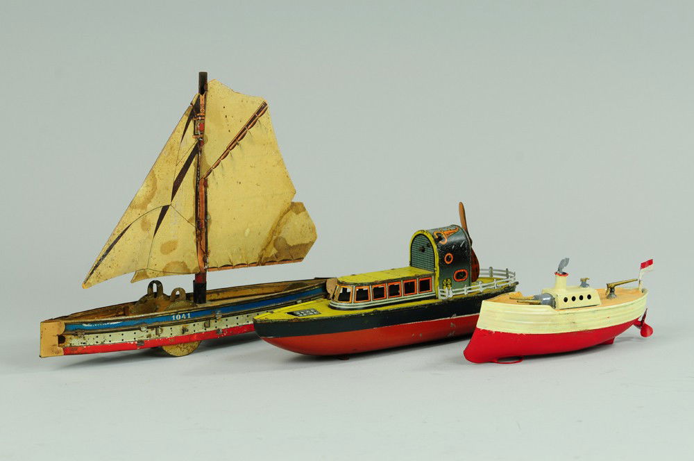 THREE NAUTICAL TOYS: Lot includes litho tin Hess Sail boat, small tin cannon boat, and deck mounted prop house cruiser boat in tin lithography. 6 to 10" l.